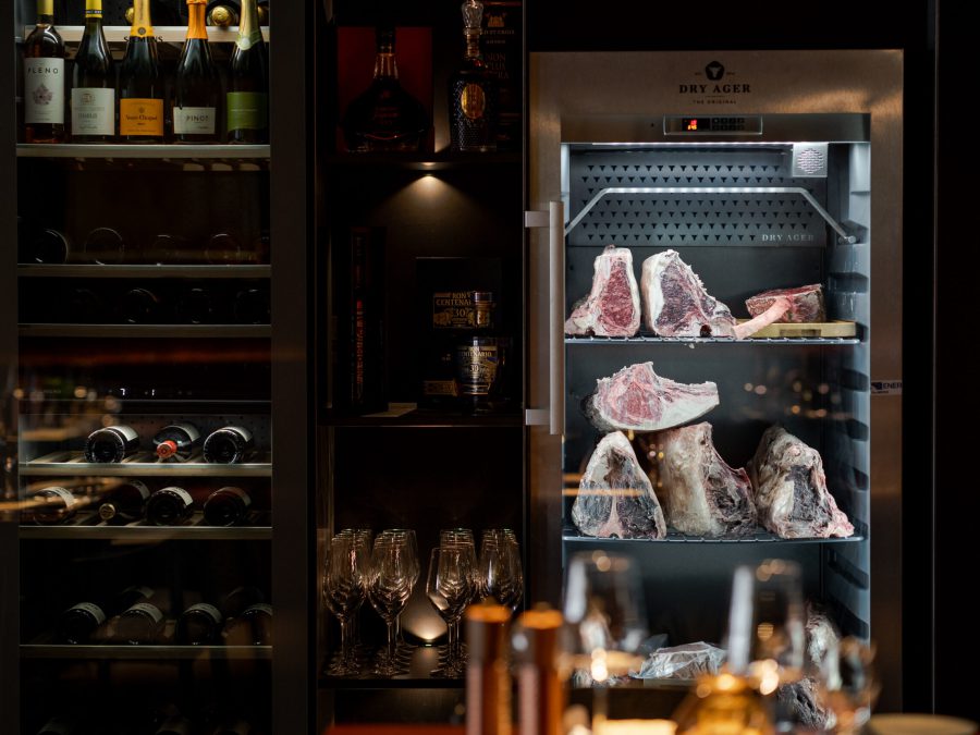 Dry-Ager-Schrank mit gereiftem Fleisch und Weinregal im Waldshuter Hof