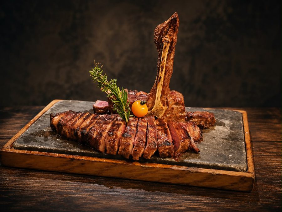 Aufgeschnittenes Tomahawk-Steak auf heißem Stein serviert im Steakhouse Waldshuter Hof